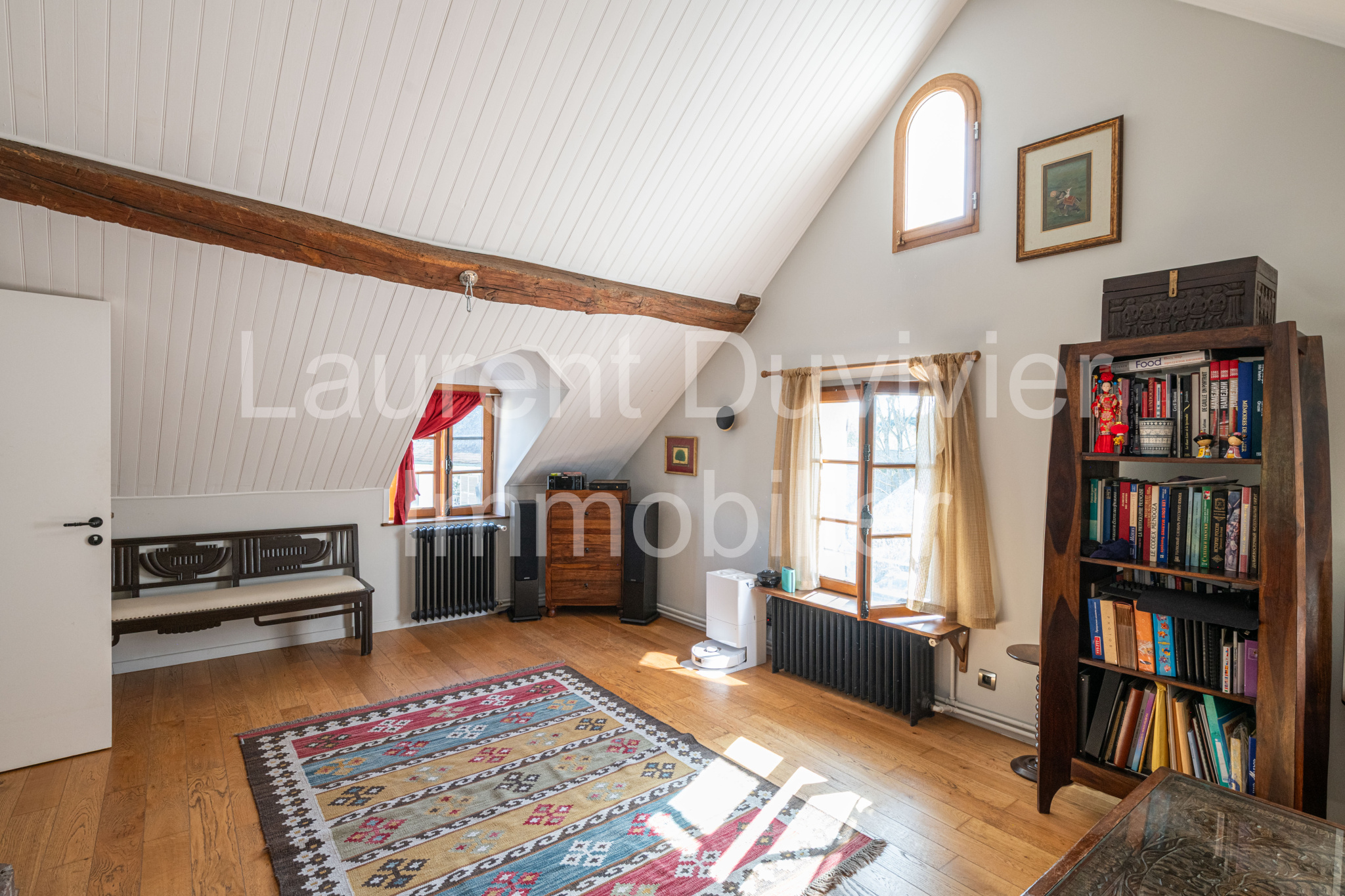 Intérieur d’une maison vigneronne rénovée Intérieur d'une maison vigneronne rénovée avec poutres apparentes et bibliothèque à Marly-le-Roi.
