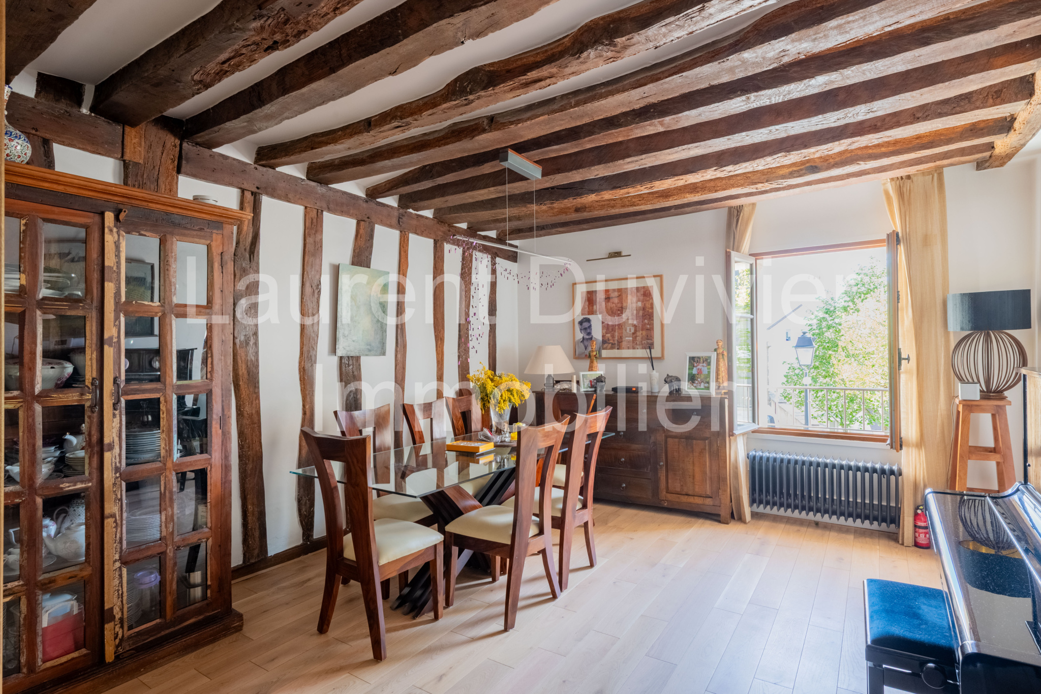 Intérieur d’une maison vigneronne rénovée Intérieur d'une maison vigneronne du XVIIe siècle rénovée avec poutres apparentes et mobilier en bois.