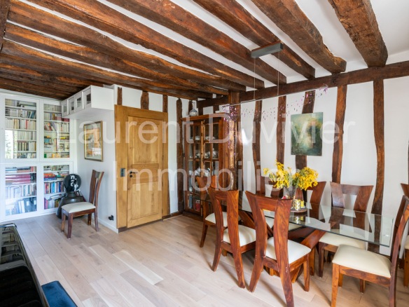 Intérieur d'une maison vigneronne rénovée avec poutres apparentes et mobilier moderne à Marly-le-Roi.