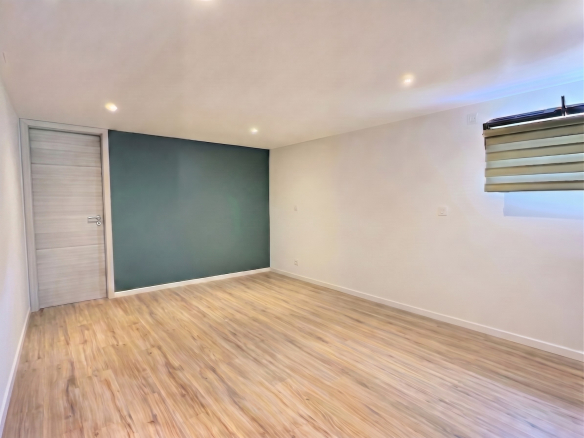 Intérieur d'une maison contemporaine avec un mur peint en vert et un sol en bois.