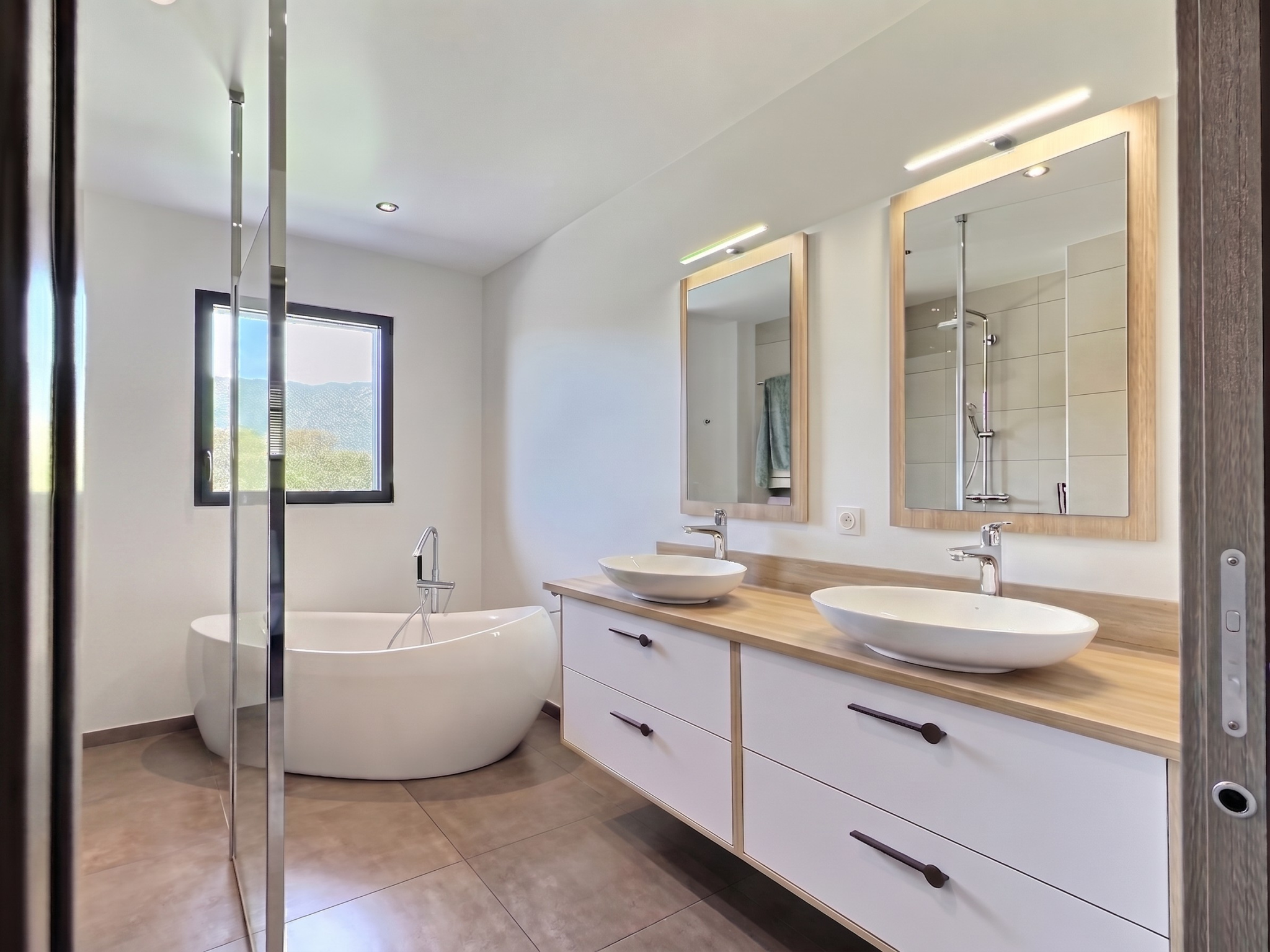 Salle de bain contemporaine Salle de bain moderne avec baignoire et double vasque dans une maison contemporaine.