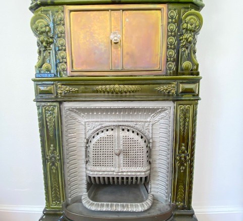 Cheminée ancienne en faïence verte avec détails décoratifs, Paris 12ème.