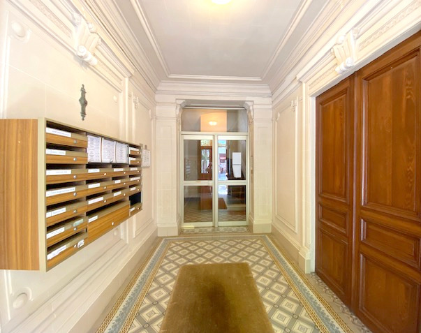 Hall d’entrée d’immeuble ancien Hall d'entrée d'un immeuble ancien avec boîtes aux lettres et sol en carreaux de ciment.