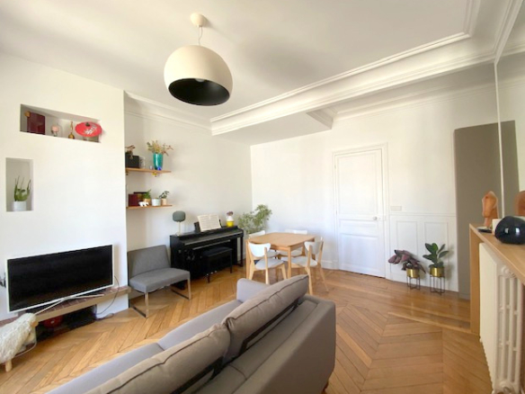 Salon lumineux d'un appartement de 3 pièces à Paris 12ème, avec parquet et mobilier moderne.