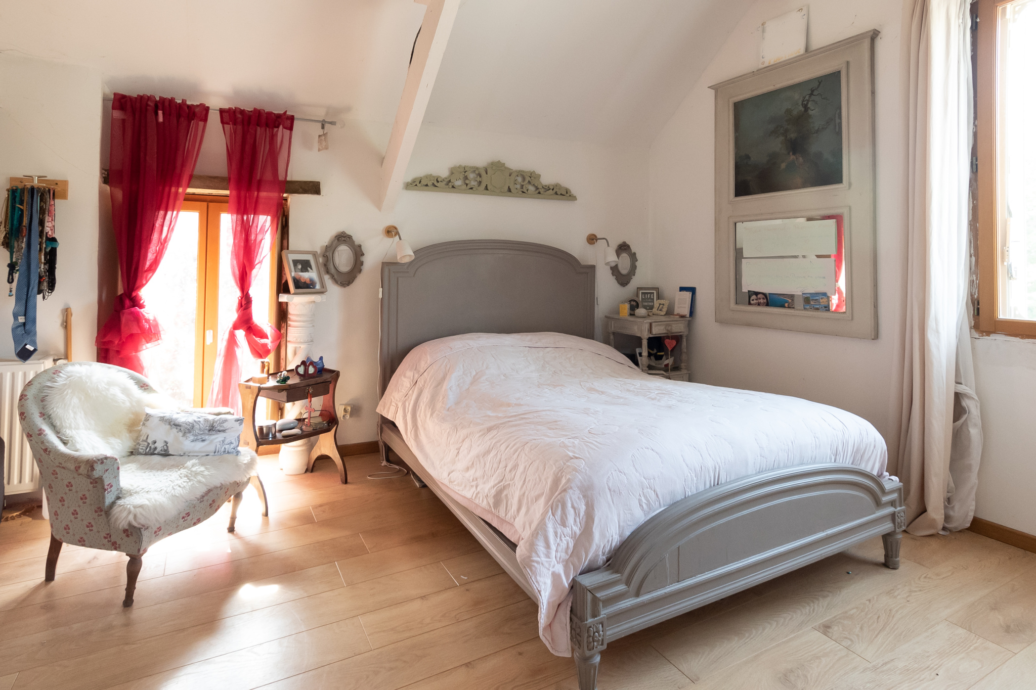 Chambre avec lit double et fauteuil dans une maison de charme à Guyancourt.
