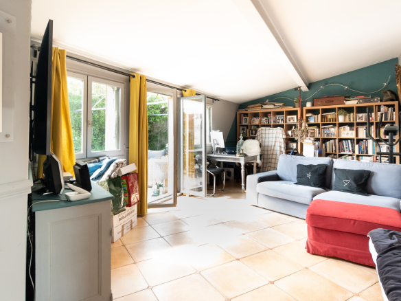 Intérieur d'une maison de charme avec un séjour lumineux et des étagères remplies de livres.