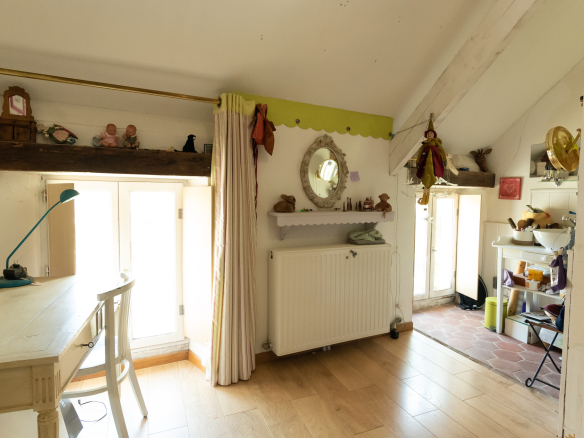 Intérieur d'une maison de charme avec un bureau et une cuisine visible à l'arrière.