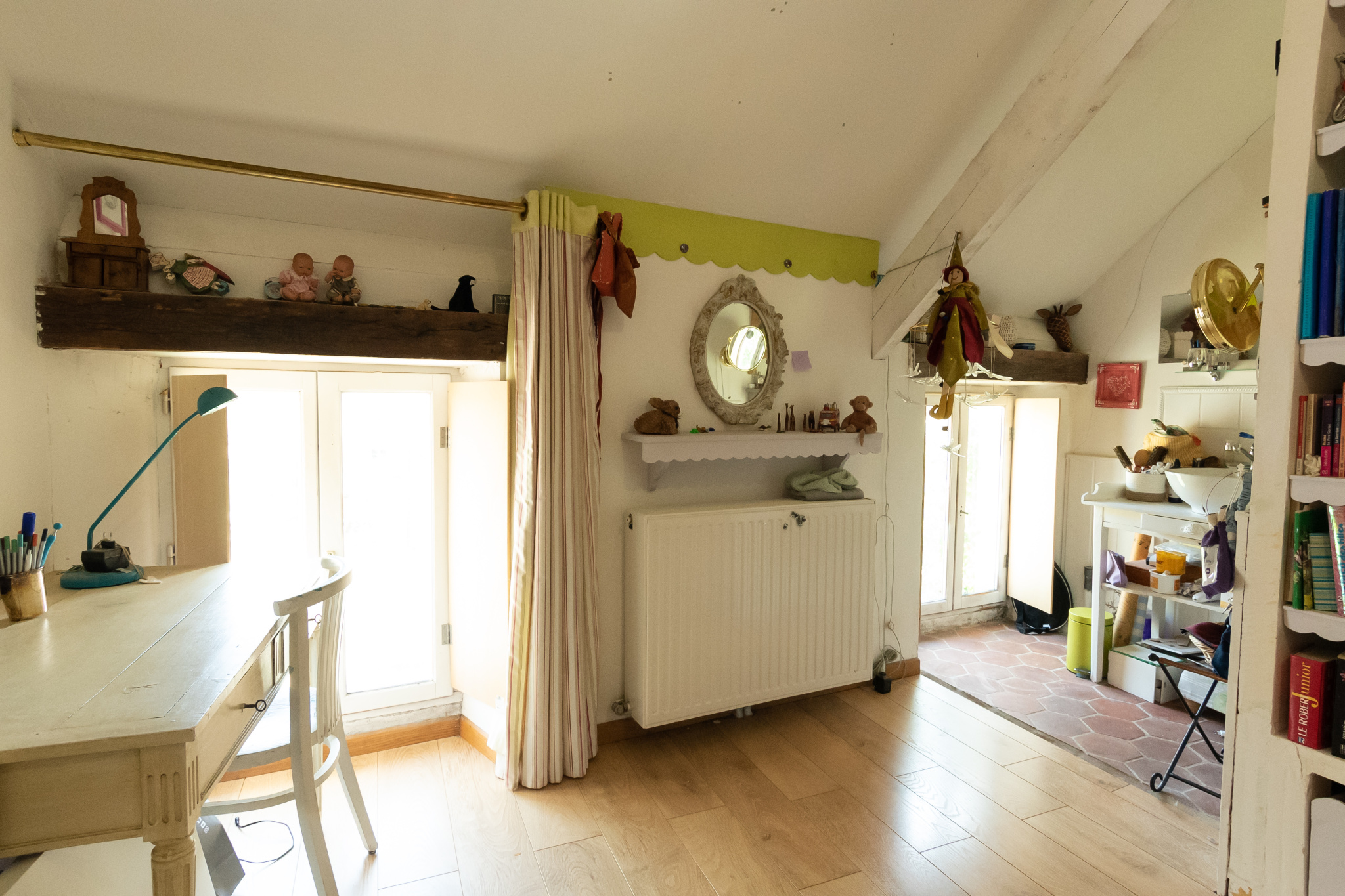 Intérieur d'une maison de charme avec un bureau et une cuisine visible à l'arrière.