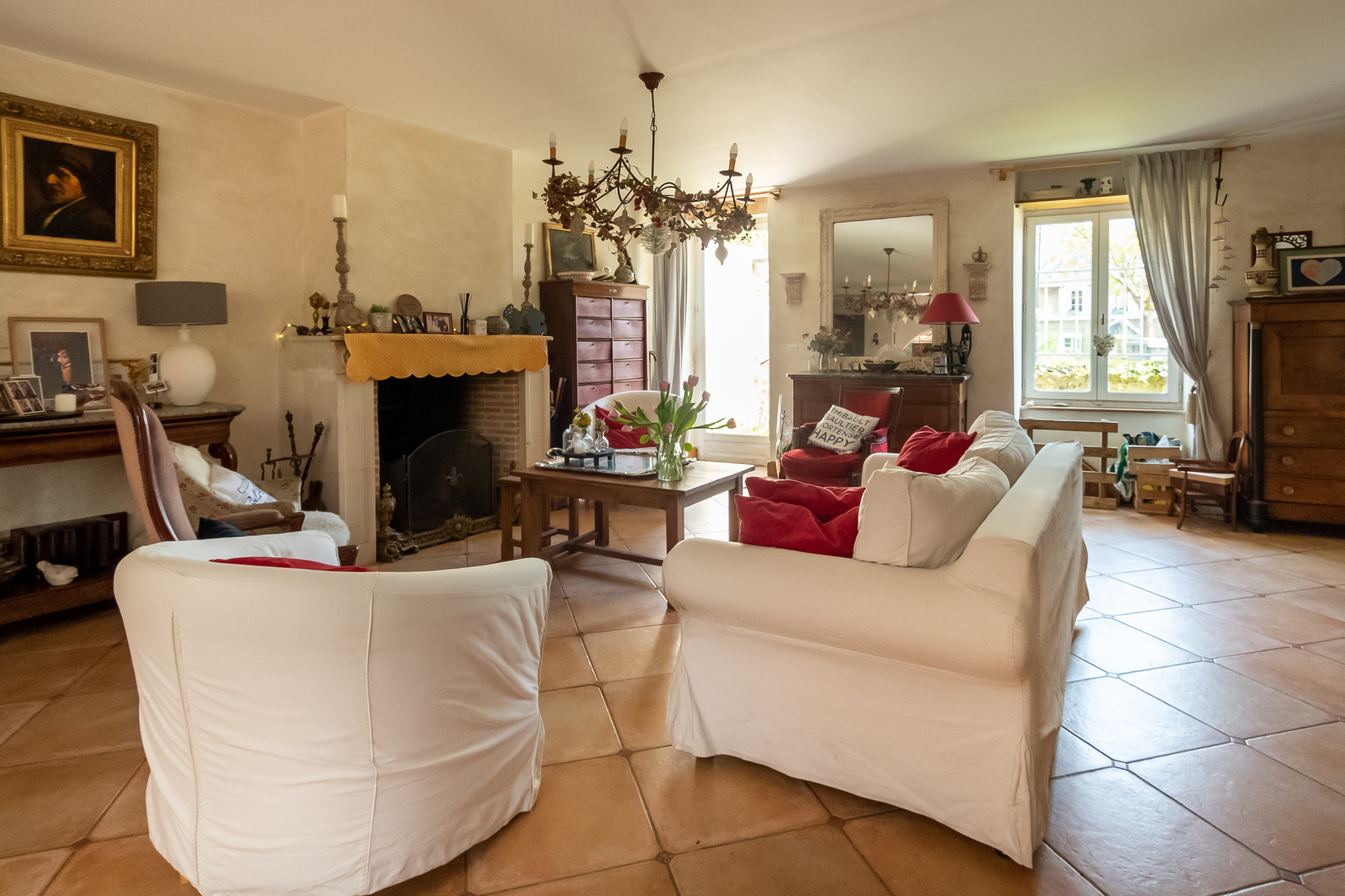 Intérieur d'une maison familiale avec un grand séjour, cheminée, et mobilier chaleureux.