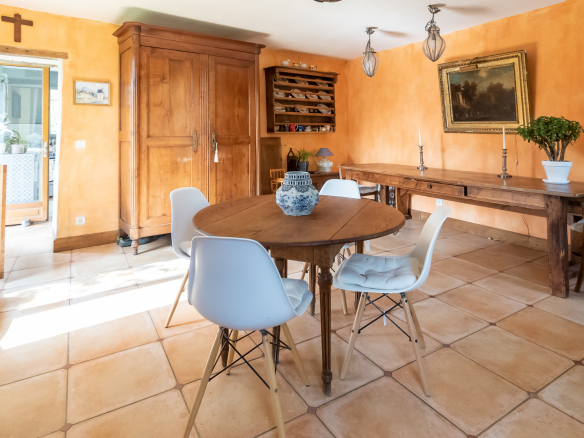 Intérieur d'une maison de charme avec salle à manger et mobilier en bois, murs orange.