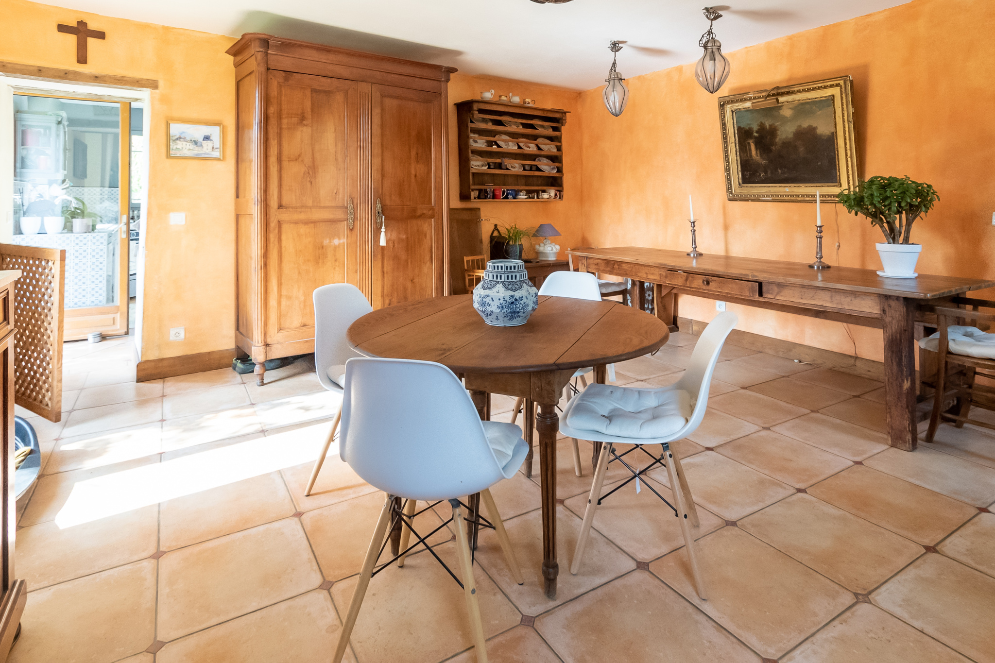 Intérieur d'une maison de charme avec salle à manger et mobilier en bois, murs orange.