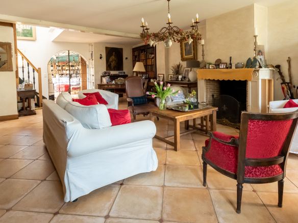 Intérieur d'une demeure de charme avec un grand séjour, cheminée et mobilier chaleureux.