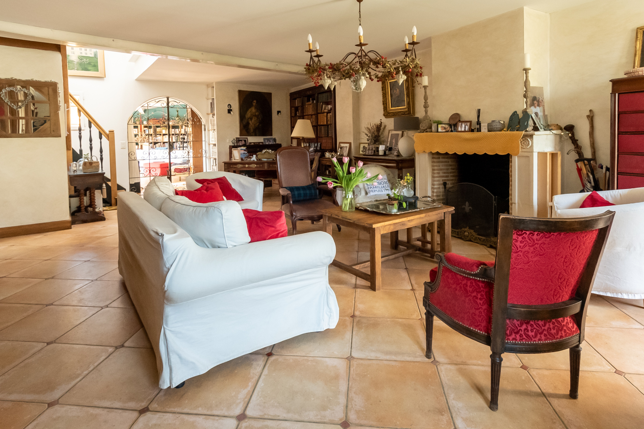 Intérieur d'une demeure de charme avec un grand séjour, cheminée et mobilier chaleureux.
