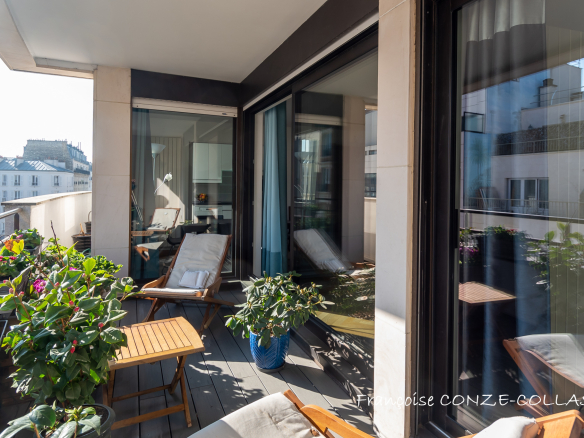 Balcon d'un appartement lumineux avec plantes et mobilier de jardin à Levallois-Perret.