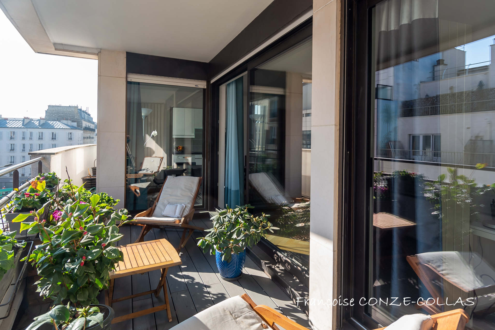 Balcon d'un appartement lumineux avec plantes et mobilier de jardin à Levallois-Perret.