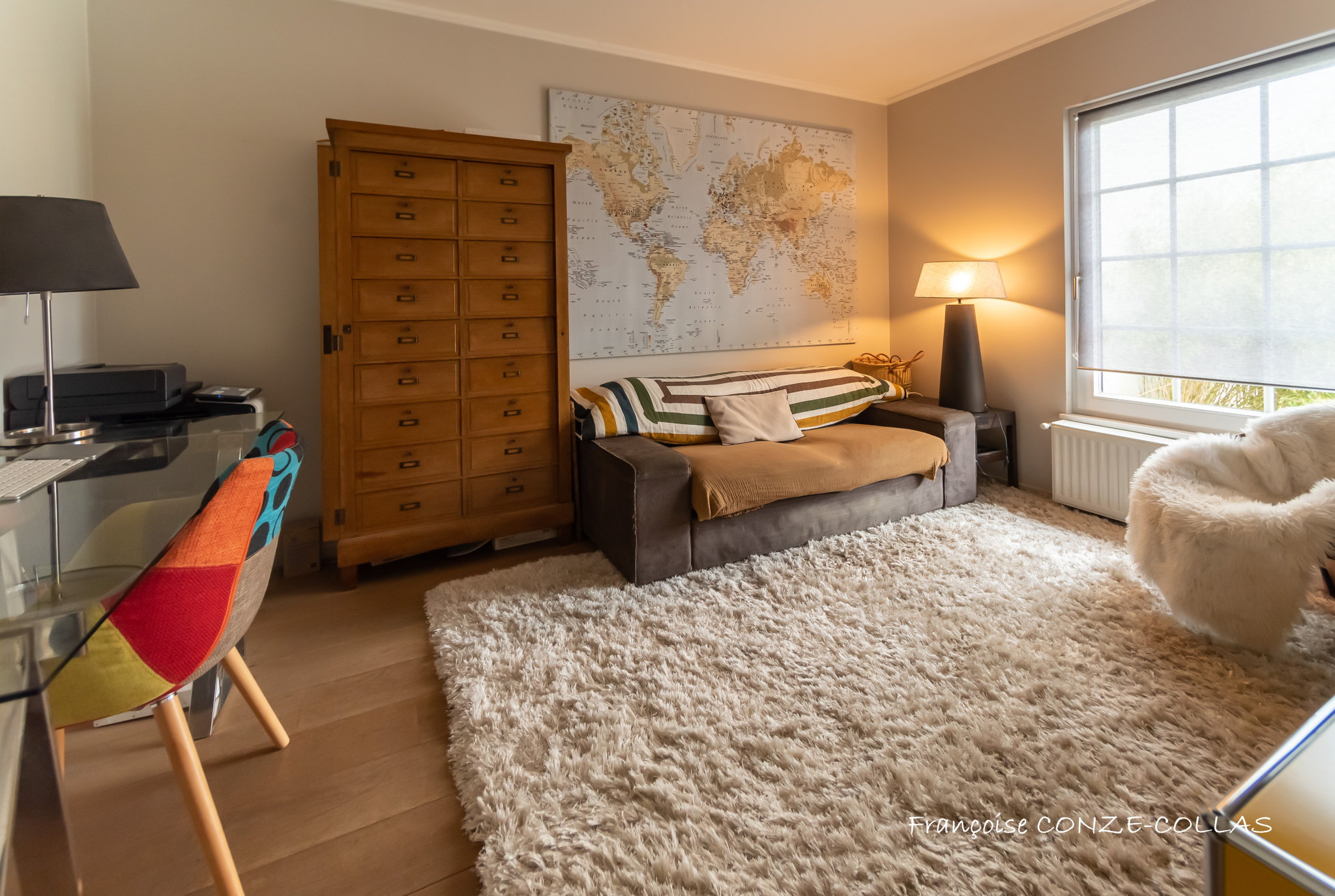 Intérieur d’une maison à Garches Intérieur d'une maison avec un canapé, un bureau et une carte du monde au mur.