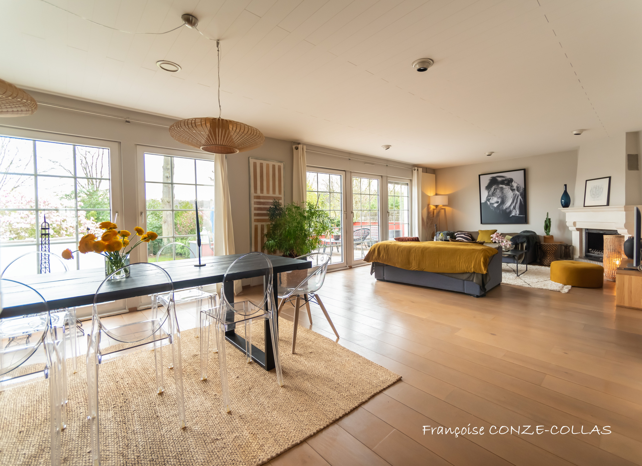 Intérieur d’une maison à Garches Intérieur d'une maison spacieuse avec salon, salle à manger et jardin visible à travers de grandes fenêtres.