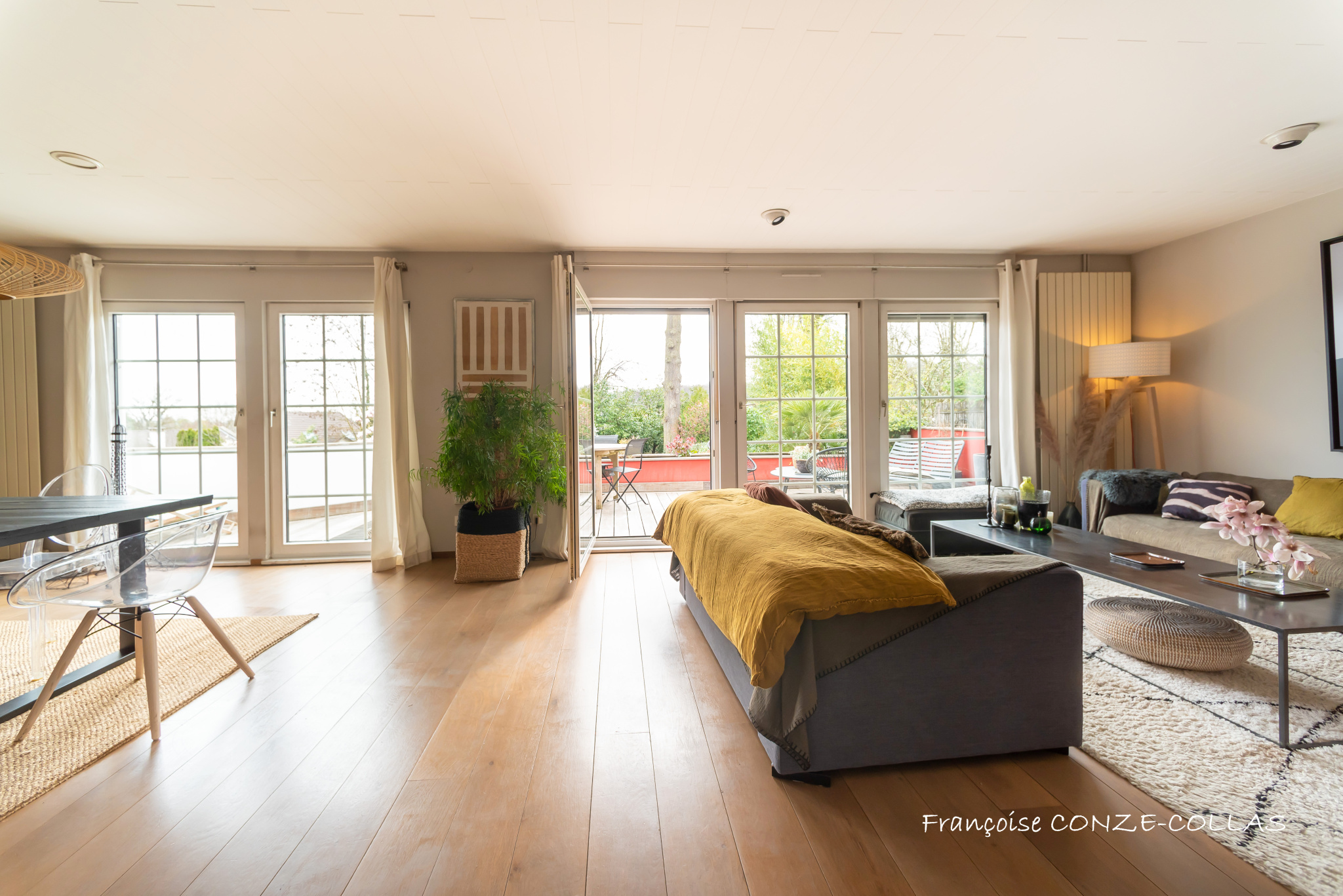 Intérieur d’une maison à Garches Intérieur d'une maison moderne avec salon lumineux, grandes fenêtres et accès à une terrasse.