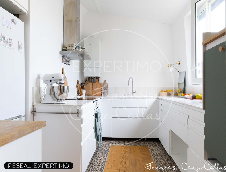 Cuisine moderne dans un appartement ancien rénové à Versailles, avec des éléments en bois et des appareils électroménagers.