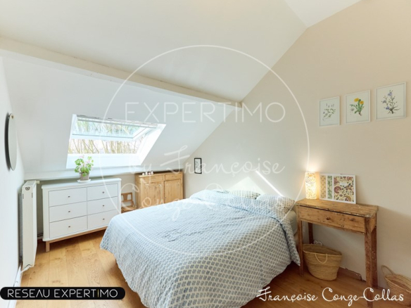 Chambre d'un appartement sous les combles avec fenêtre de toit et décoration simple.