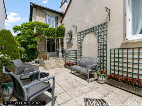 Terrasse d'une maison à vendre avec des chaises et des plantes, Marnes-la-Coquette.