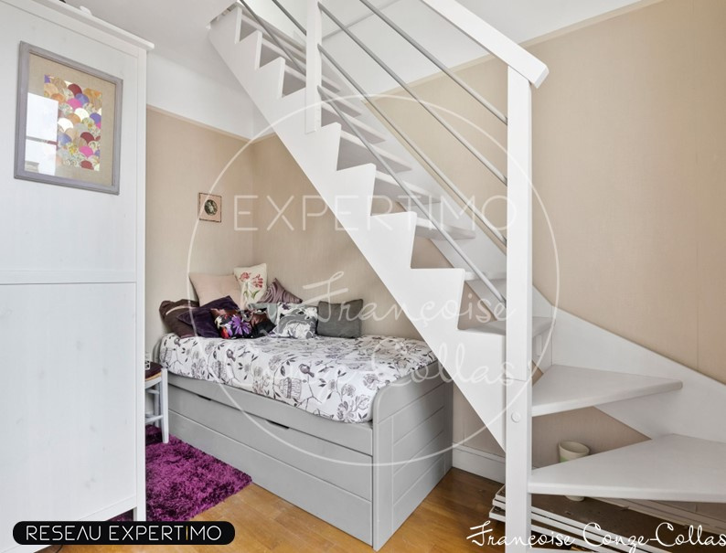 Chambre dans une maison à vendre Chambre avec lit et escalier dans une maison à vendre à Marnes-la-Coquette.