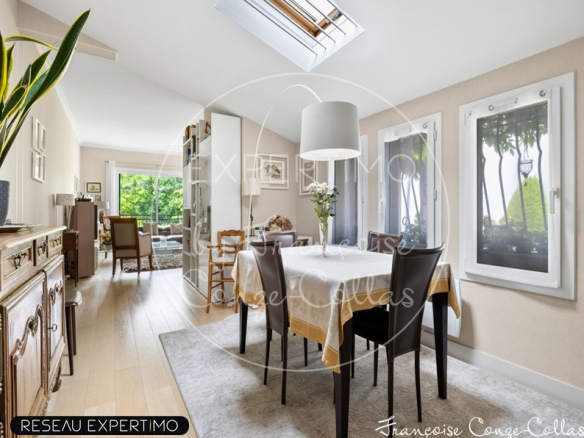 Intérieur d'une maison à vendre avec une salle à manger lumineuse et des fenêtres donnant sur le jardin.