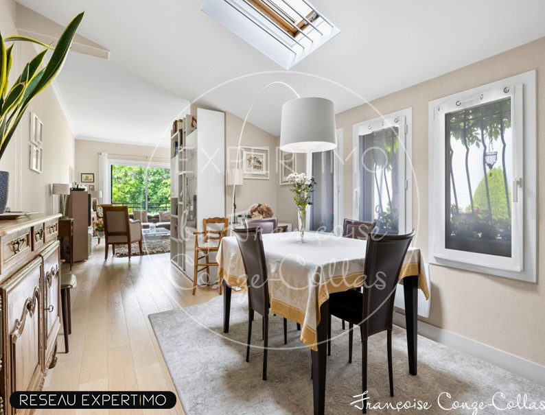 Intérieur d’une maison à vendre à Marnes-la-Coquette Intérieur d'une maison à vendre avec une salle à manger lumineuse et des fenêtres donnant sur le jardin.