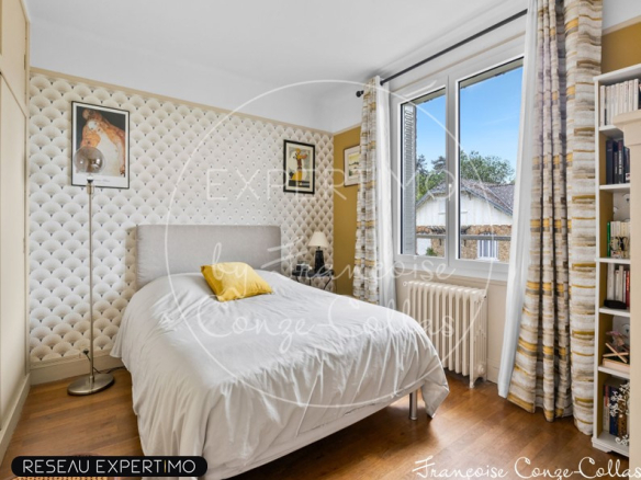 Chambre d'une maison à vendre, avec un lit simple et des murs décorés.