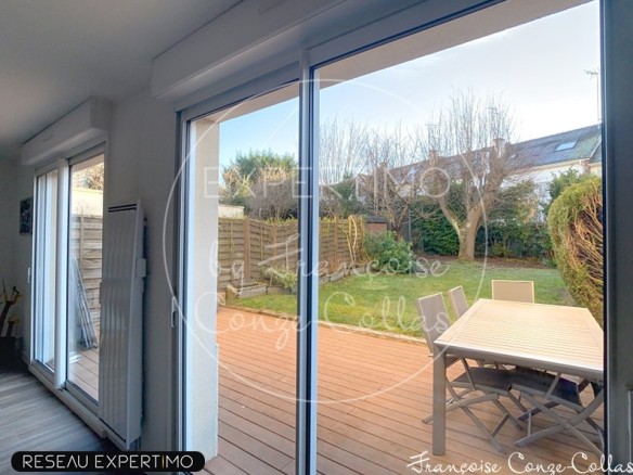 Vue intérieure d'une maison avec accès à une terrasse et jardin.