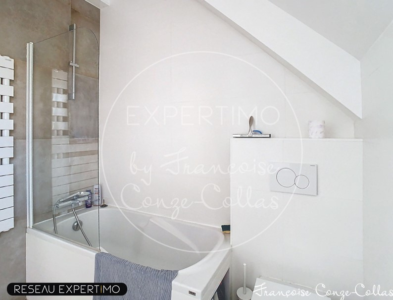 Salle de bain moderne Salle de bain moderne avec baignoire et douche, murs clairs et fenêtre.