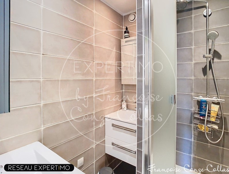 Salle de bain moderne Salle de bain moderne avec douche et lavabo, carrelage gris.