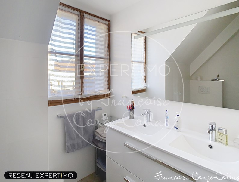 Salle de bains lumineuse Salle de bains moderne avec lavabo et miroir, fenêtres laissant entrer la lumière.