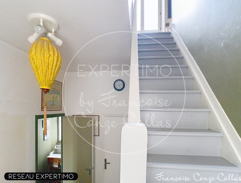 Escalier d’un duplex à Versailles Escalier intérieur d'un duplex avec un lampadaire jaune et une horloge murale.