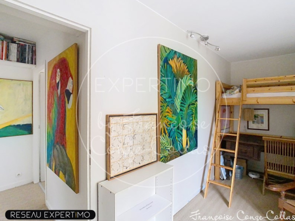 Intérieur d'un duplex à Versailles avec des œuvres d'art sur les murs et un espace de vie lumineux.