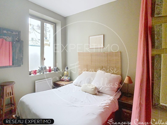 Chambre d'un appartement duplex à Versailles avec lit double et décor chaleureux.