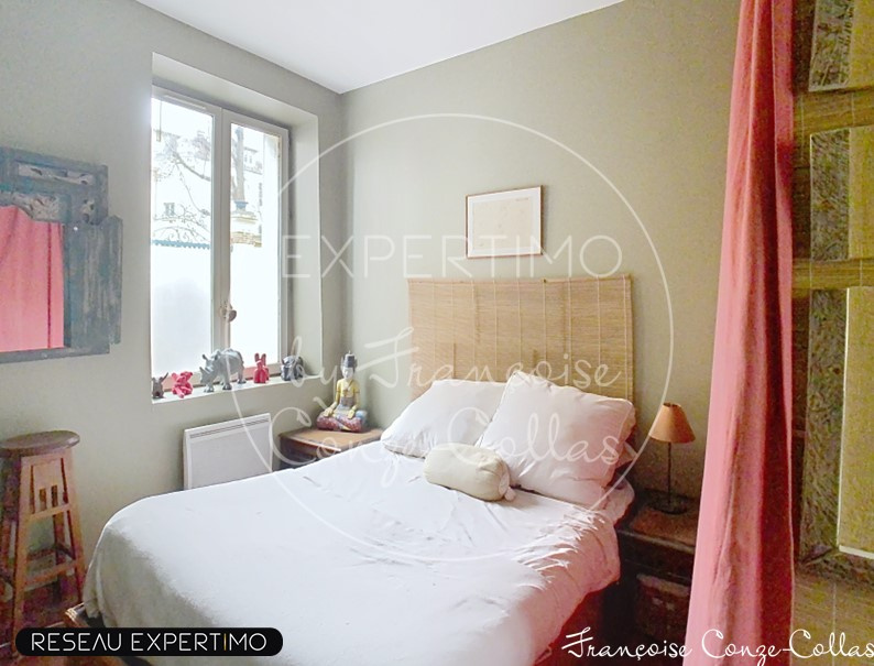 Chambre d’appartement duplex à Versailles Chambre d'un appartement duplex à Versailles avec lit double et décor chaleureux.