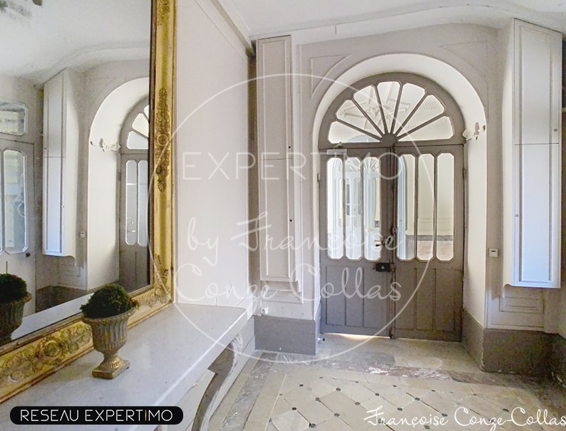Entrée d’appartement à Versailles Entrée d'un appartement dans un immeuble ancien avec miroir et portes en bois.