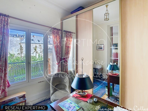 Chambre d'un appartement à Versailles avec vue sur jardin et miroir.