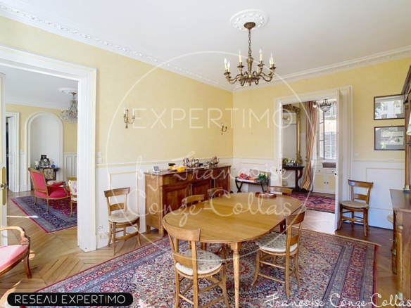 Salle à manger d'un appartement ancien à Versailles, avec table en bois et décoration classique.