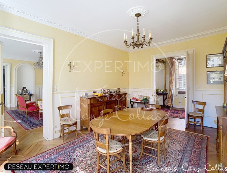 Salle à manger dans un appartement à Versailles Salle à manger d'un appartement ancien à Versailles, avec table en bois et décoration classique.