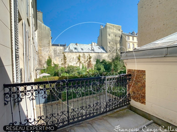 Balcon d'un appartement avec vue sur un jardin dans un immeuble ancien à Versailles.