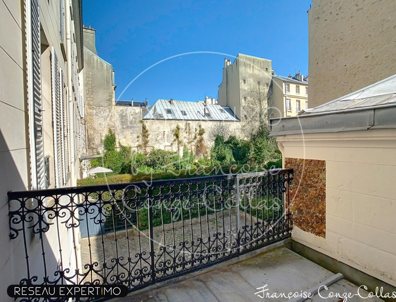Balcon avec vue sur jardin Balcon d'un appartement avec vue sur un jardin dans un immeuble ancien à Versailles.