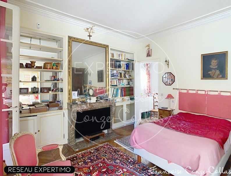 Chambre d’appartement à Versailles Chambre d'un appartement ancien à Versailles avec un lit, une bibliothèque et un tapis.