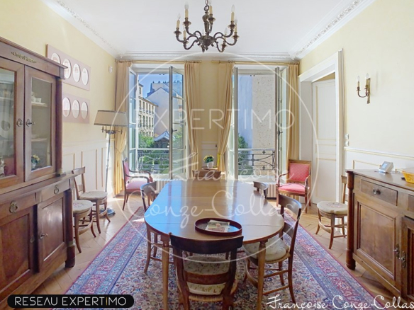 Salle à manger d'un appartement ancien à Versailles, avec vue sur jardins, mobilier en bois et tapis.