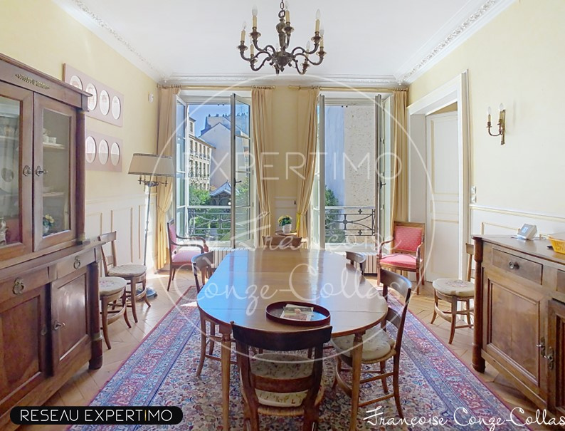 Salle à manger d’un appartement à Versailles Salle à manger d'un appartement ancien à Versailles, avec vue sur jardins, mobilier en bois et tapis.