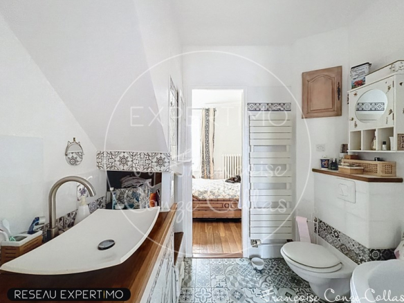 Bathroom with bathtub, decorative tiles and toilet, millstone house in Chaville.