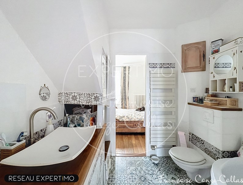 Bathroom with bathtub, decorative tiles and toilet, millstone house in Chaville.