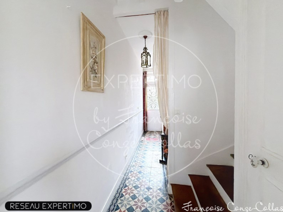 Interior of a millstone house with a bright hallway and a colorful tiled floor.