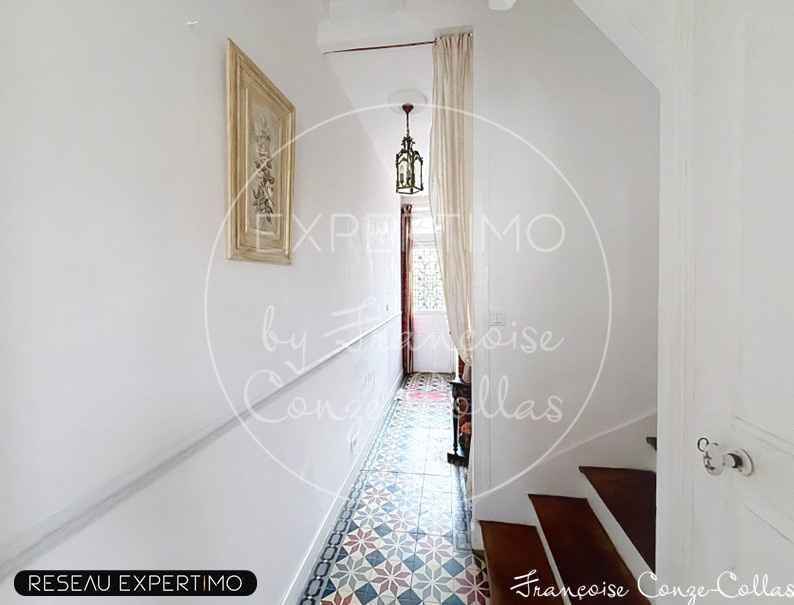 Interior of a millstone house with a bright hallway and a colorful tiled floor.